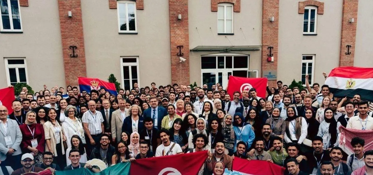 مجموعة كبيرة من المشاركين في المؤتمر يحملون أعلام بلدانهم في كراكوف